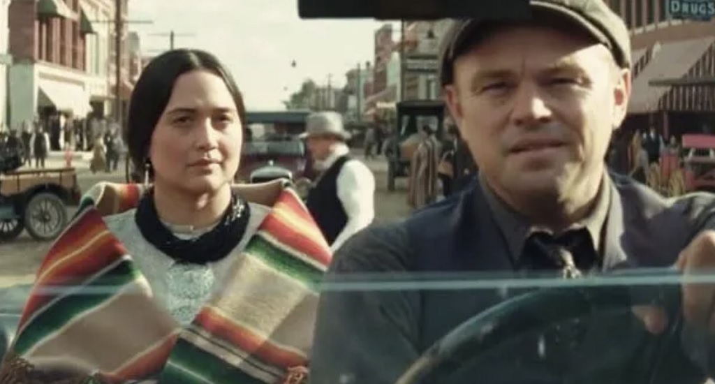 Ernest (Leo DiCaprio) chauffeurs for Mooly (Lily Gladstone)