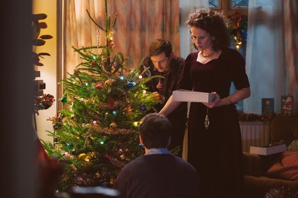 Adam (Andrew Scott) around the Christmas Tree with his Mum and Dad (Claire Foy and Jamie Bell) in "All of us Strangers"