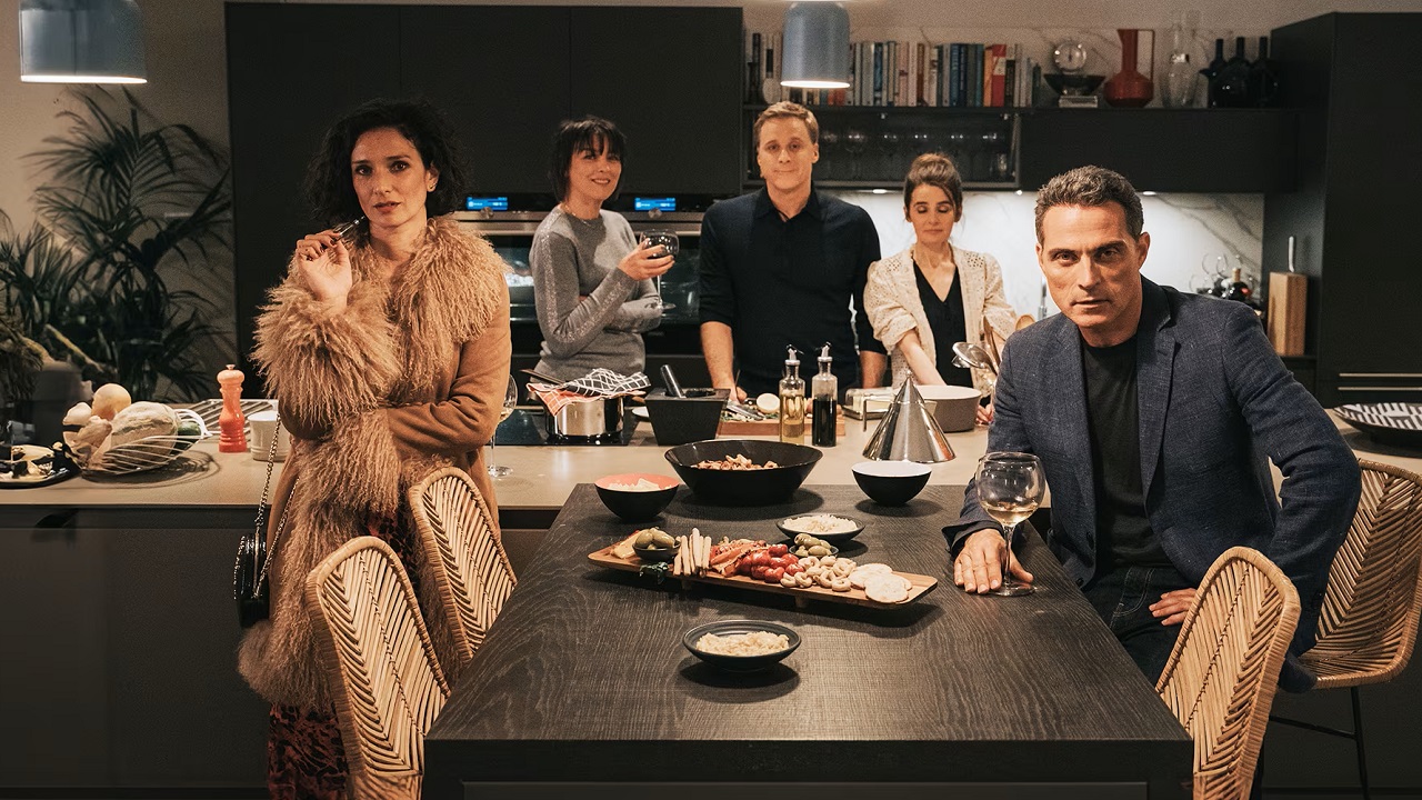 The group of friends stand around the dinner table looking at the camera in Parkland Picture's "The Trouble with Jessica"