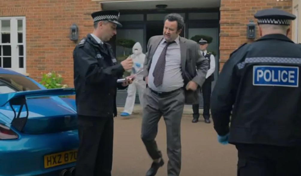 DCI Chris Hudson talks to other police officers outside the scene of a murder in The Thursday Murder Club