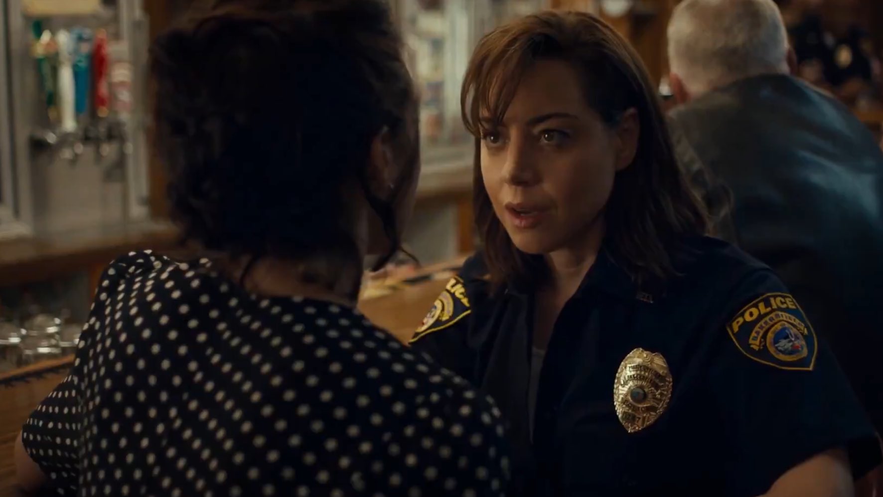 Honey (Margaret Qualley) and MG (Aubrey Plaza) face to face in a bar in Honey Don't.