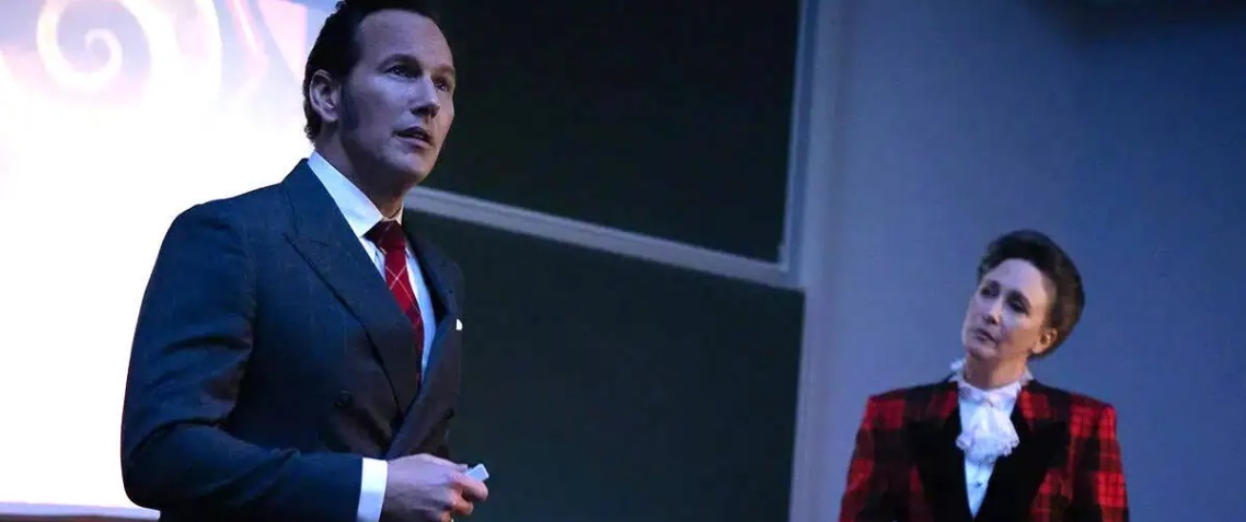 Ed and Lorraine Warren (Patrick Wilson and Vera Farmiga) present slides to an audience in The Conjuring: Last Rites