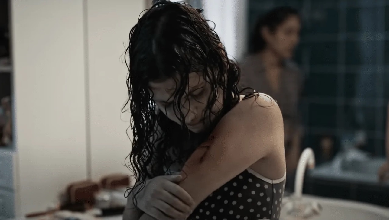 Mélissa Boros examining her bleeding tattoo in Alpha.