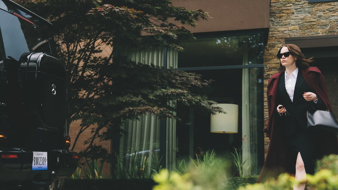 Michelle Fuller (Emma Stone) leaves home dressed for business in Bugonia.