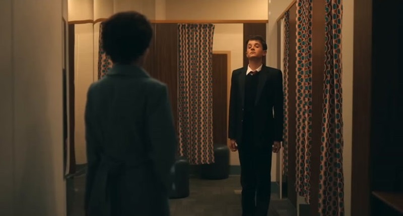 A younger Robert (Scott Ellis Watson) trying on his school uniform at the shops with his mum (Shirley Henderson) in I Swear.