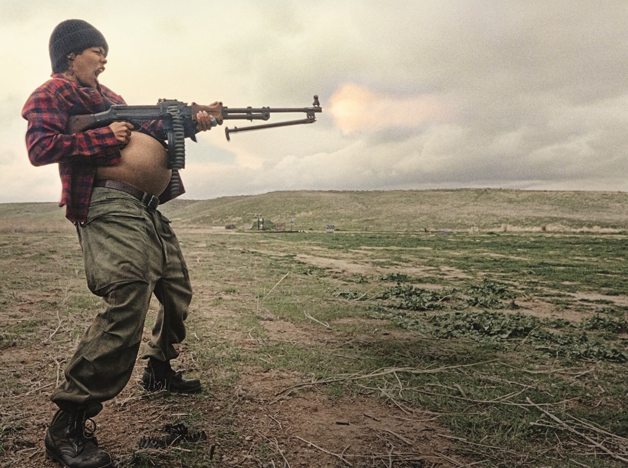 A heavily pregnant Perfidia (Teyana Taylor) fires a machine gun on a practice range in One Battle After Another
