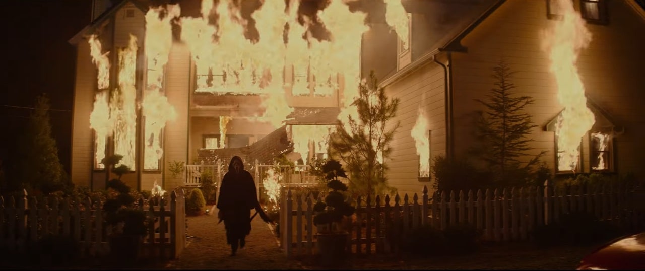 Ghostface walks from a burning house in Scream 7.