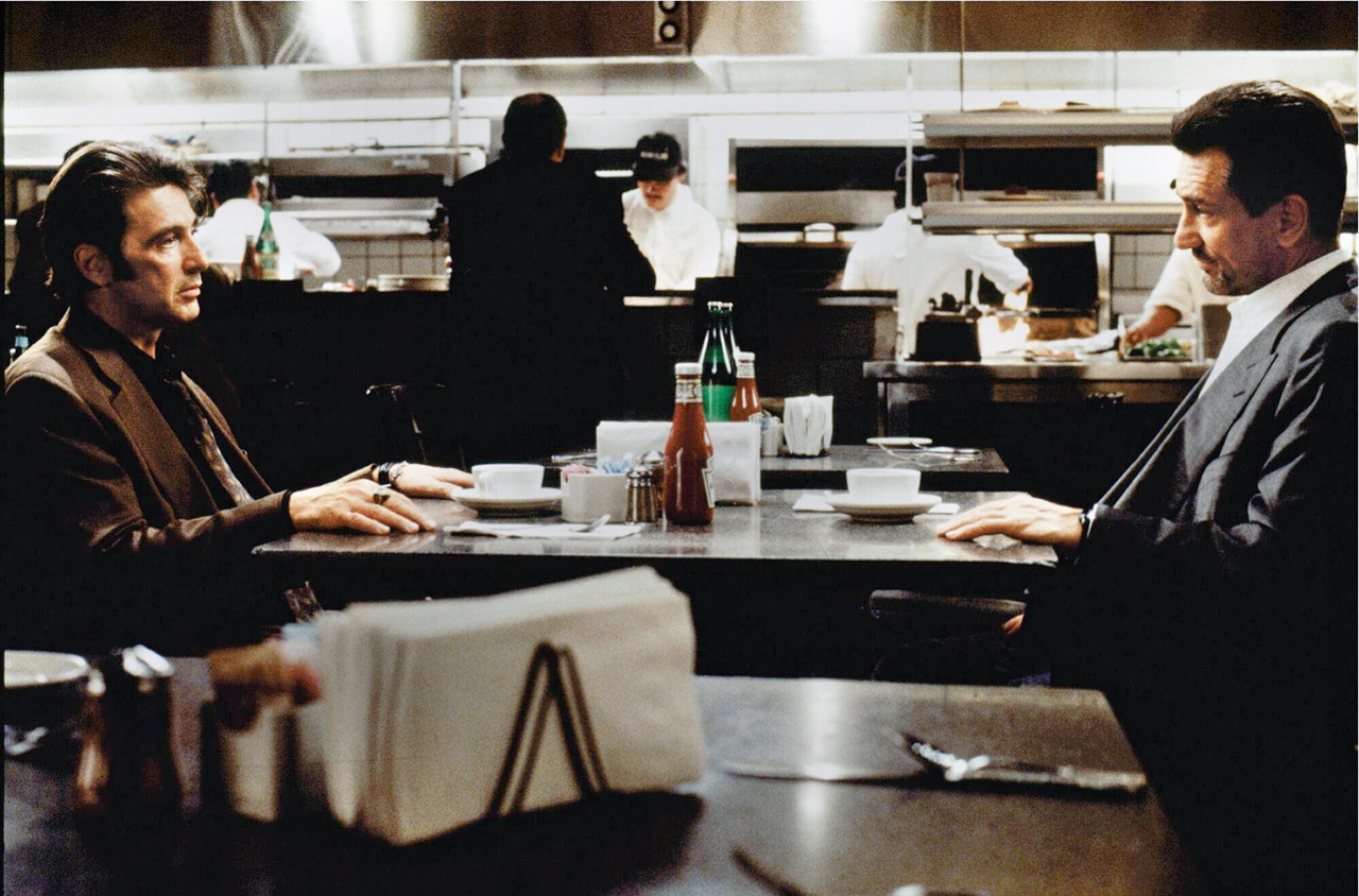 Vincent Hanna (Al Pacino) and Neil McCauley (Robert De Niro) sit face to face across a diner table