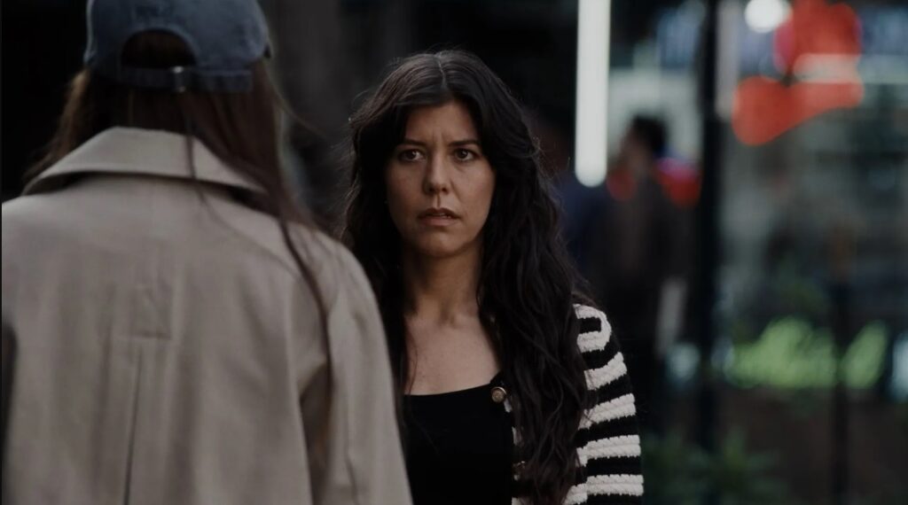 Sophie (Zoe Winters) talks to Lucy (Dakota Johnson) in the street in Materialists