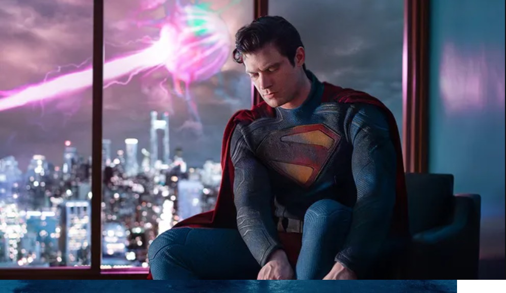 Superman adjusting his boot while a space battle is going on in the skies behind him.