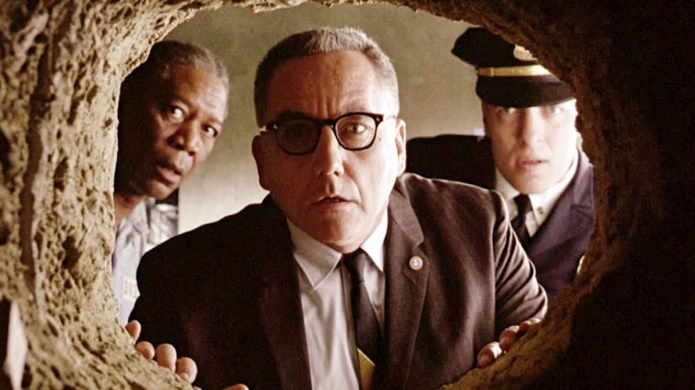 The prison warden looks in disbelief at a hole made in the cell wall in The Shawshank Redemption.