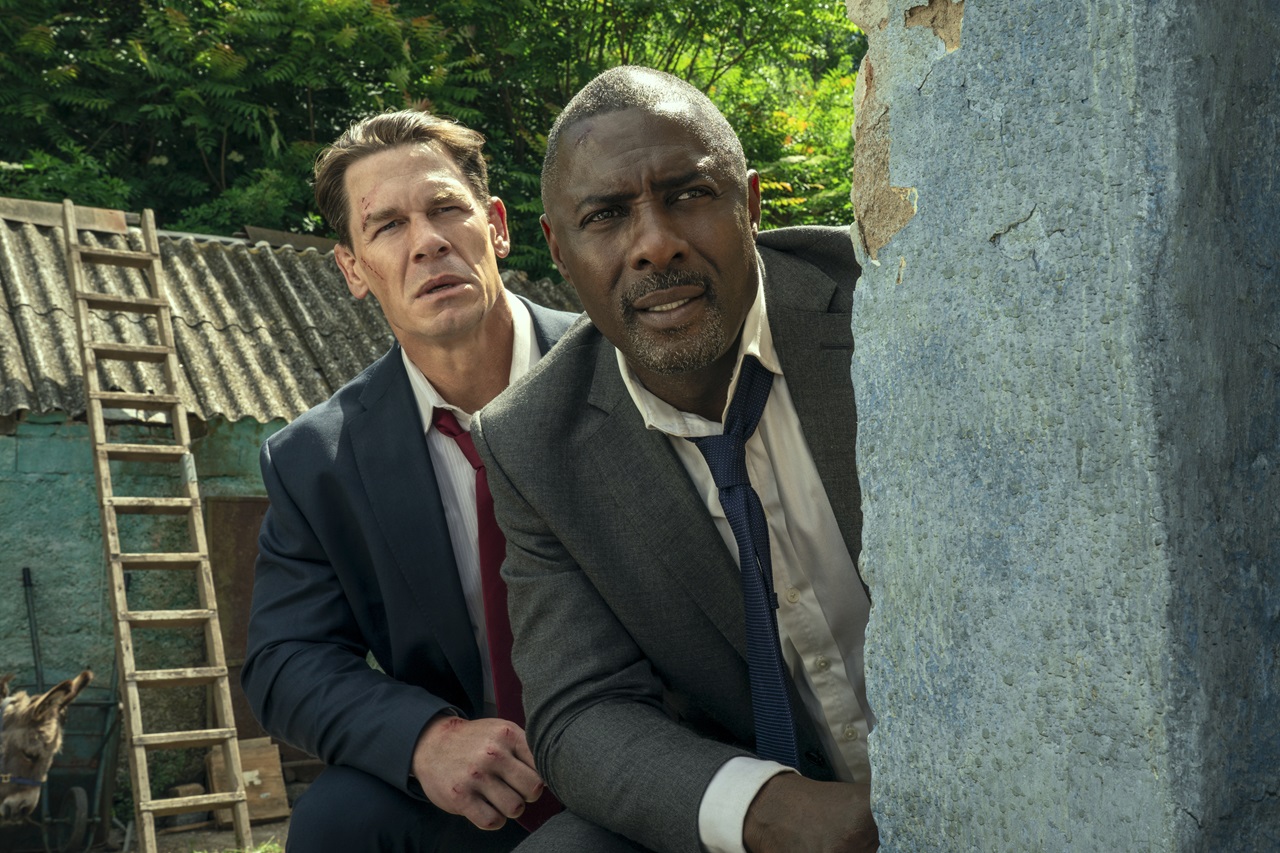 British Prime Minister, Sam Clarke (Idris Elba) and the US President, Will Derringer (John Cena) peek out from behind a wall in Heads of State.
