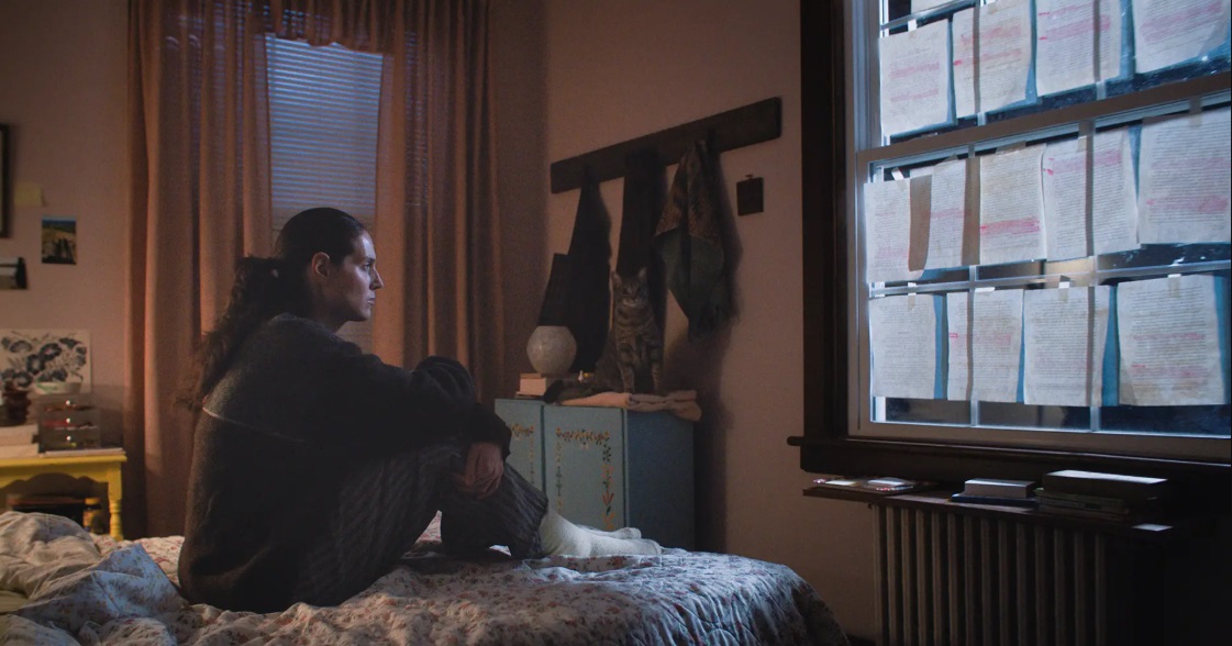 Agnes stares at her bedroom window covered in pages of her thesis in Sorry Baby.