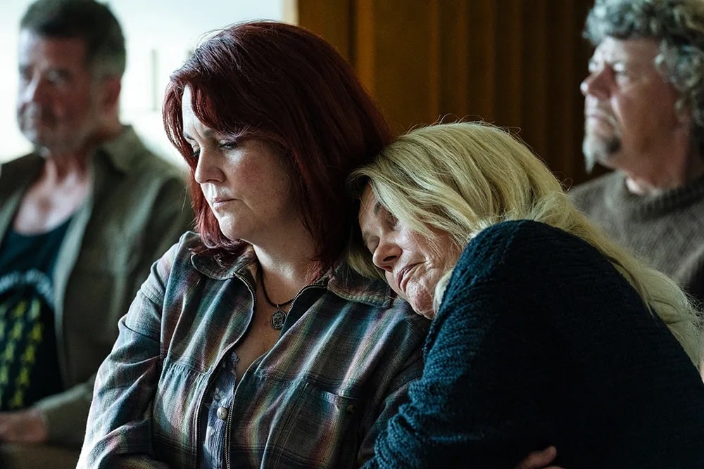 Sonya (Robyn Malcolm), with her head on the shoulder of Anna (Melanie Lynskey) in Pike River.