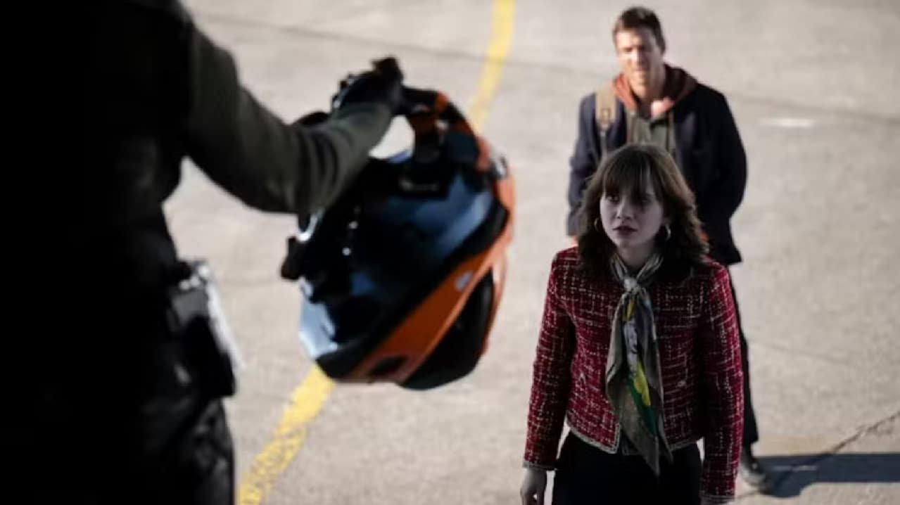 Amelia Williams (Emilia Jones) about to board a plane with Ben Richards (Glen Powell) in The Running Man (2025)