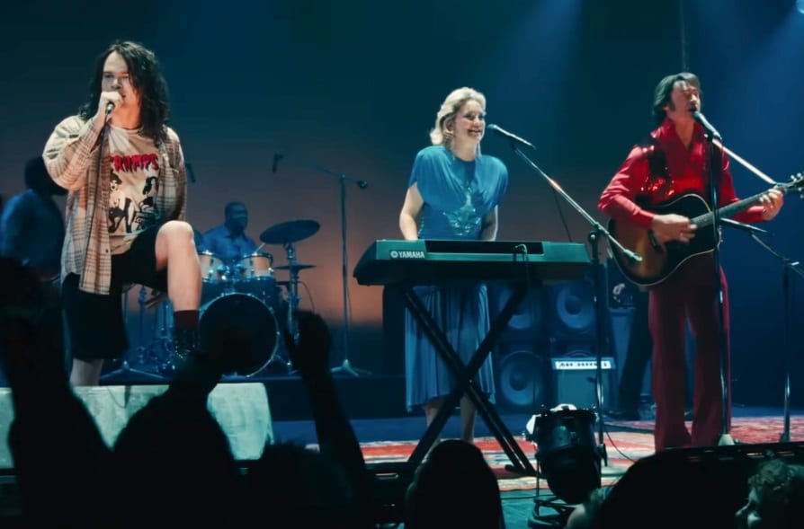 Eddie Vedder (John Beckwith) of Pearl Jam joins Lightning (Hugh Jackman) and Thunder (Kate Hudson) on stage in Song Sung Blue.