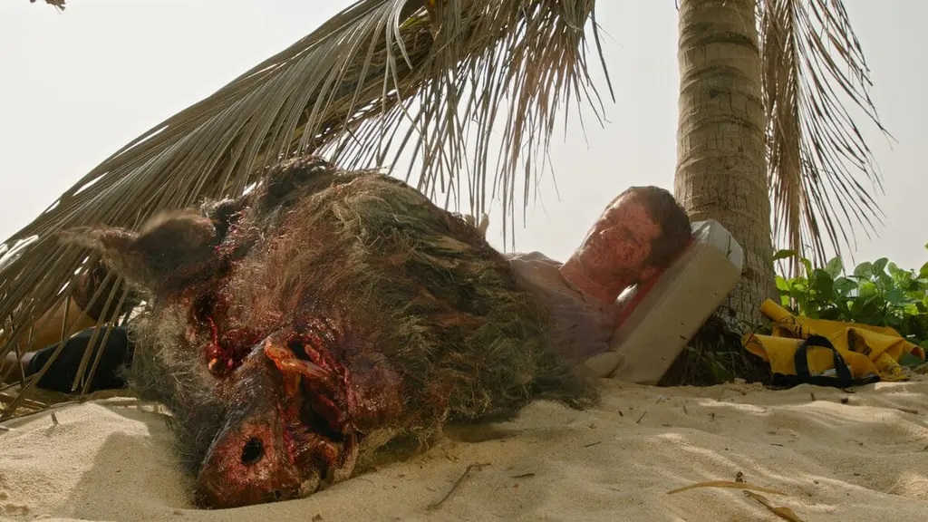 The head of a wild boar is thrown towards Bradley (Dylan O'Brien) in Send Help.
