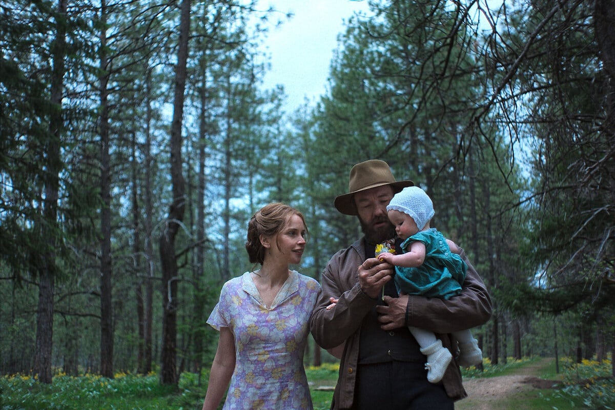  Gladys (Felicity Jones), Robert (Joel Edgerton) and baby Kate walk along a forest road in Train Dreams.