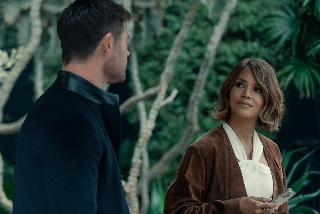 David (Chris Hemsworth) chats with Sharon (Halle Berry) on the kerb-side in Crime 101.