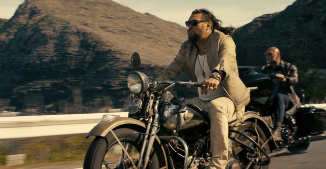 James (Dave Bautista) and Jonny (Jason Momoa) ride motorcycles along the highway in The Wrecking Crew 