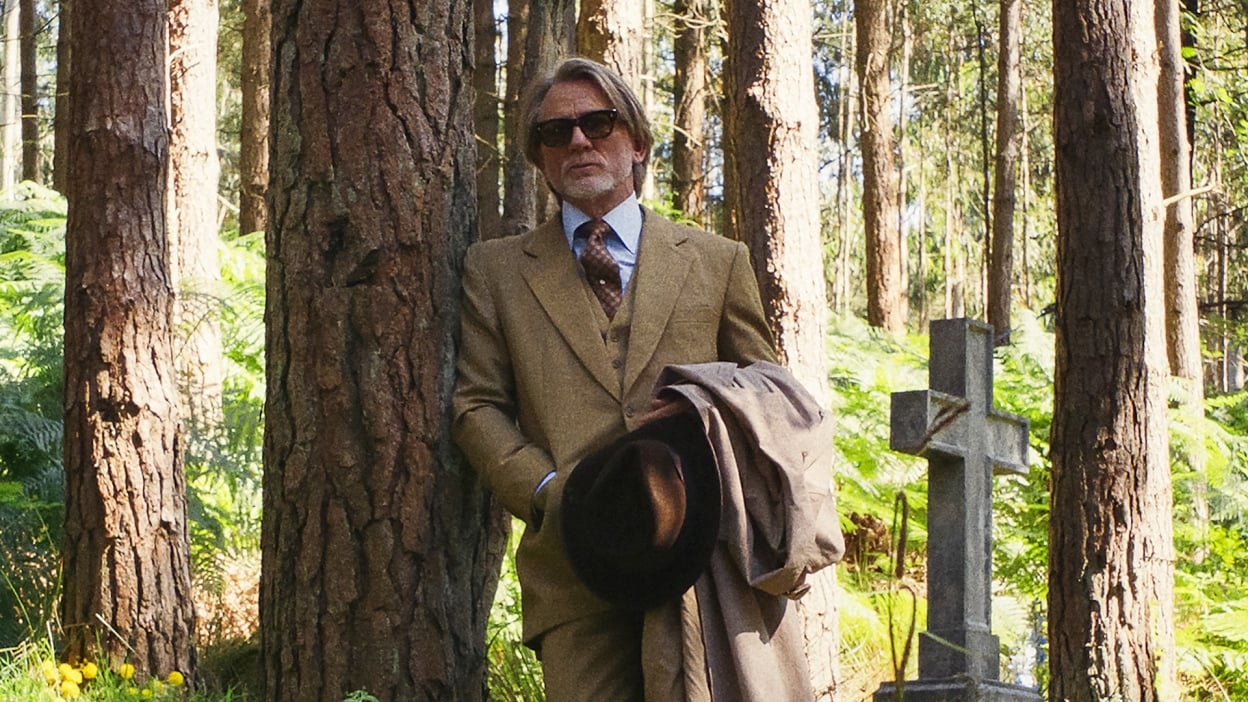 Benoit Blanc (Daniel Craig) watches in a churchyard in Wake Up Dead Man.