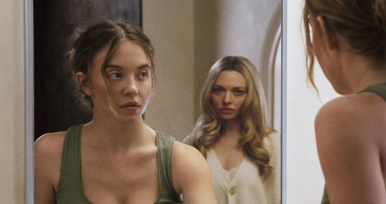 Millie (Sydney Sweeney) suddenly sees Nina (Amanda Seyfried) in the bathroom mirror in The Housemaid. 